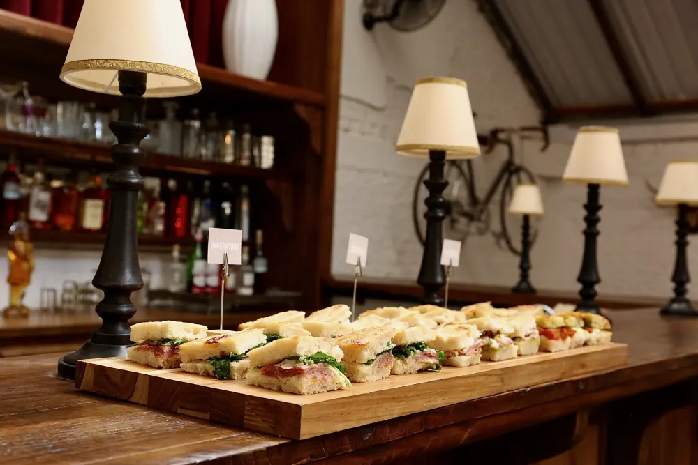 Tábua de paninis montada no balcão, entre luminárias